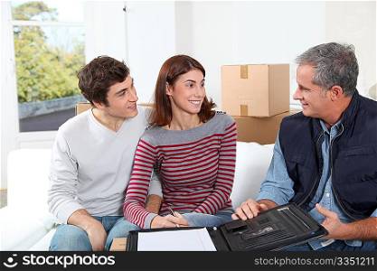 Young couple signing contract for home moving