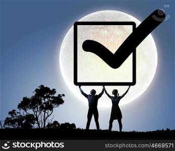 Young couple. Silhouettes of young couple holding checkbox with tick