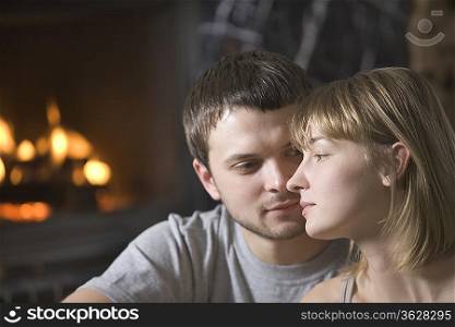 Young couple sit at open fire