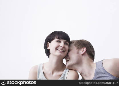 Young couple sit laughing in vest tops copyspace