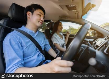 young couple sitting and driving in a car
