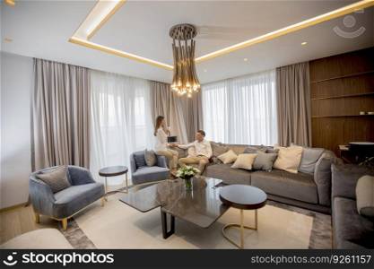 Young couple sitting and relaxes in the luxury living room