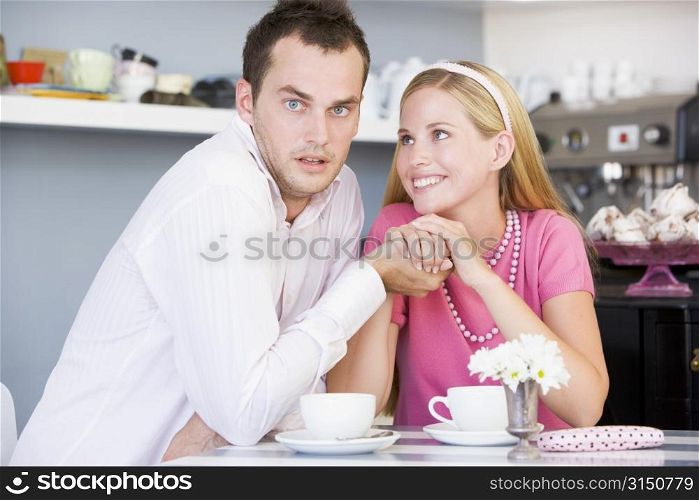 Young couple sitting at a table and having tea together