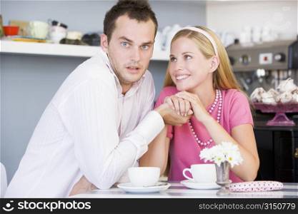 Young couple sitting at a table and having tea together