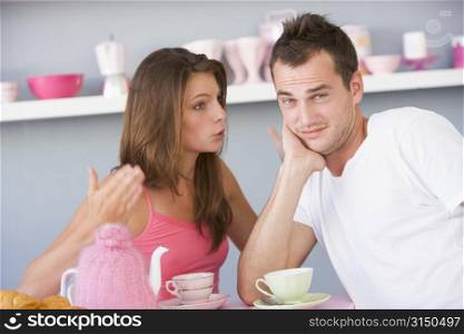 Young couple sitting at a table arguing
