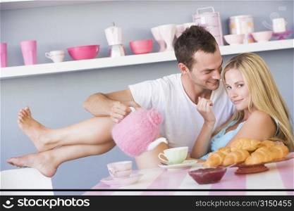 Young couple sitting at a table flirting and having tea