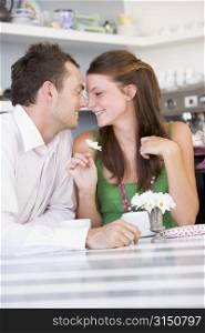 Young couple sitting at a table looking into each other&acute;s eyes