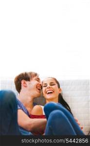 Young couple sitting at couch and laughing &#xA;
