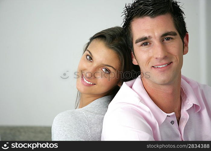 Young couple sitting back to back