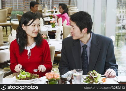Young couple sitting in a restaurant looking at each other