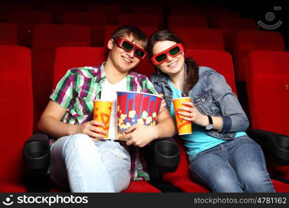 Young couple sitting in cinema and watching movie