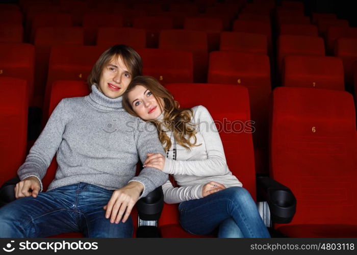 Young couple sitting in cinema and watching movie