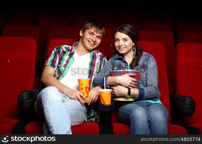 Young couple sitting in cinema and watching movie