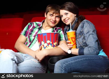 Young couple sitting in cinema and watching movie