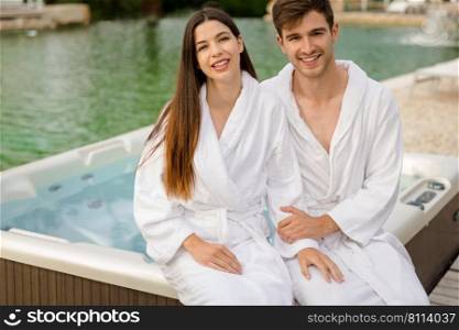 Young couple sitting near a jacuzzi in a luxury hotel