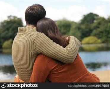 Young couple sitting near lake
