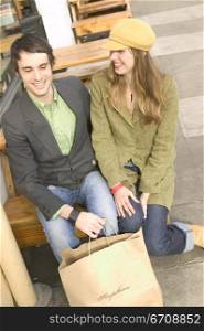 Young couple sitting on a bench and smiling