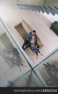 Young couple sitting on a sofa in the luxury living room, using a tablet computer top view