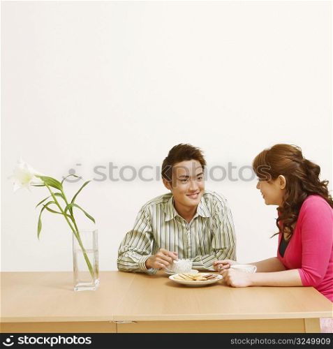 Young couple sitting on chairs and looking at each other
