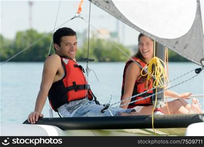 young couple sitting on sailboat