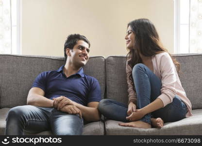 Young couple sitting on sofa at home