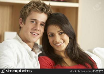 Young Couple Sitting On Sofa Together