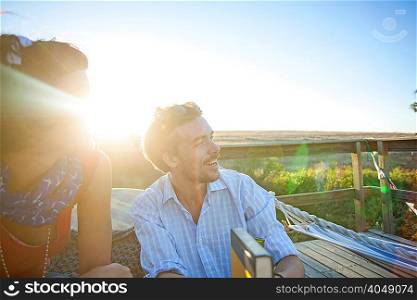 Young couple sitting on sunny balcony and smiling