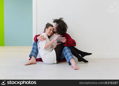 Young Couple sitting on the floor and using interent on digital tablet