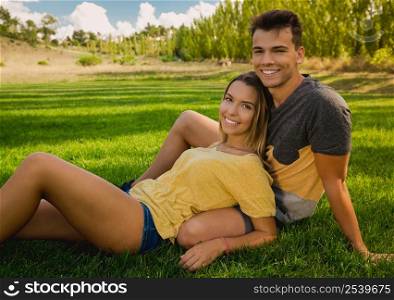 Young couple sitting on the grass and relaxing