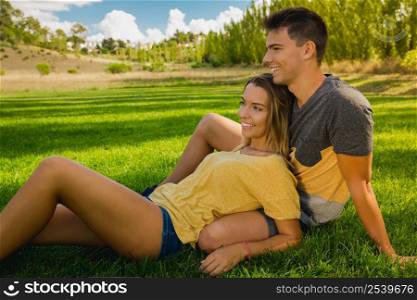 Young couple sitting on the grass and relaxing
