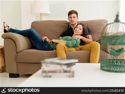 Young couple sitting on the sofa and watching movies