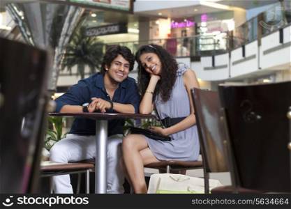 Young couple sitting together in shopping mall