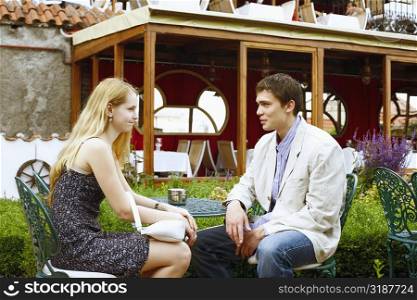 Young couple sitting together outdoors