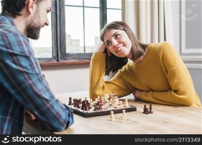 young couple sitting together playing chess home