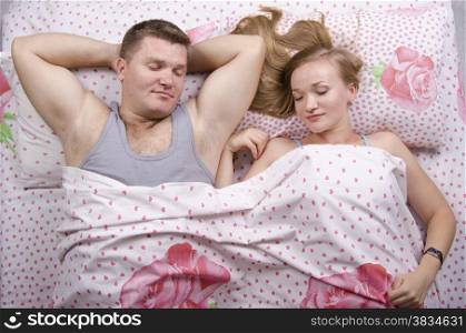Young couple sleeping in bed under the belt blanket. Photo made at the top