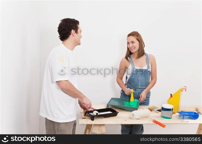 Young couple smiling at each other while mixing paint