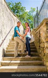 Young couple smiling holding hands on stairs romantic portrait