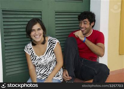 Young couple smiling in front of a door