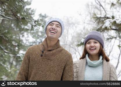 Young couple smiling in park in winter