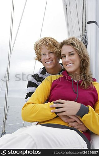 Young couple smiling on sailboat, portrait