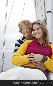 Young couple smiling on sailboat, portrait