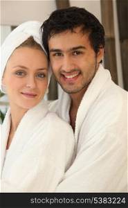 Young couple smiling wearing bathrobe