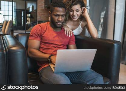 Young couple spending time together while using a laptop at home.