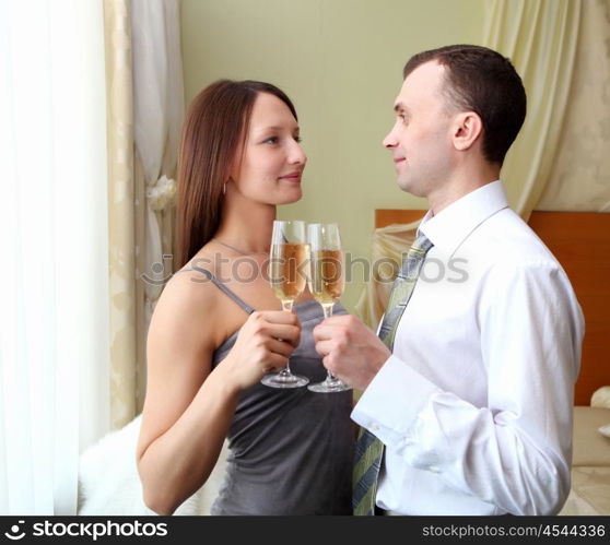 young couple standing and holding glasses champagne