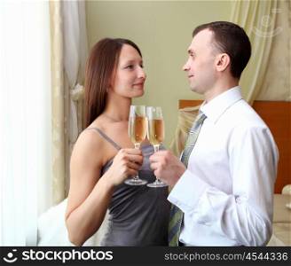 young couple standing and holding glasses champagne