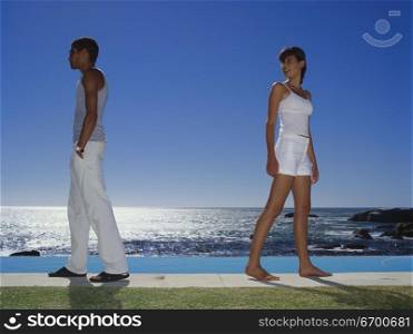 Young couple standing back to back