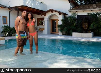 Young couple standing in swimming pool