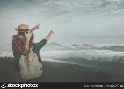 Young couple standing on a hilltop, Romantic moment of couple cuddling at view point, Black shadow loving people hug and kiss, Hiking concept.