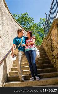 Young couple standing on stairs smiling looking at each other