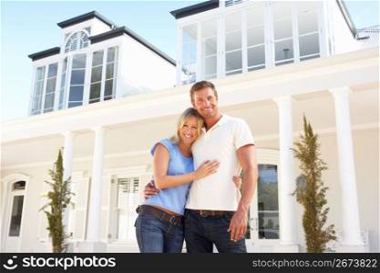 Young Couple Standing Outside Dream Home